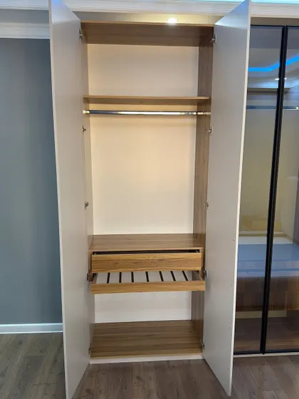 This is the interior of the side cabinet, showing a standard layout with a hanging rod and a pull-out drawer, perfect for everyday clothing.