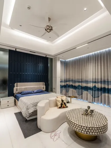 The view from the side highlights the beautiful, ocean-inspired curtains that complement the blue accent wall. The room is a perfect balance of bold design choices and serene, calming elements.