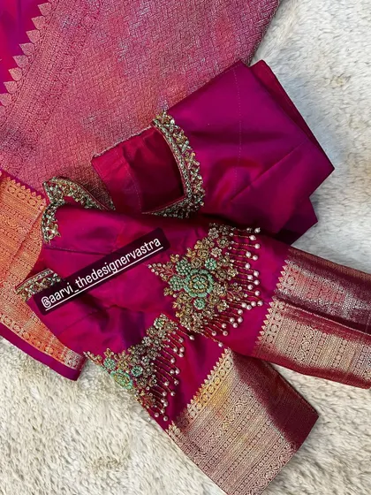 A close up of the sleeve of the pink blouse, showing the detailed zardozi and beadwork creating a beautiful floral bunch.