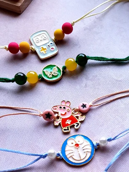 A spotlight on some of my most-loved character Rakhis for kids. You can see Peppa Pig and Doraemon alongside a cute gaming console charm, all on simple, colorful threads.