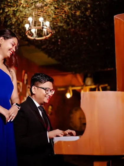 Another angle of their musical love story. The warm lighting and genuine smiles make this a heartwarming and romantic photograph.