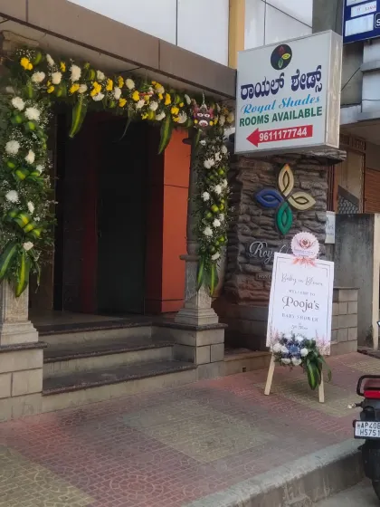 The entrance to a venue decorated for a baby shower, featuring a floral arch and a welcome sign.