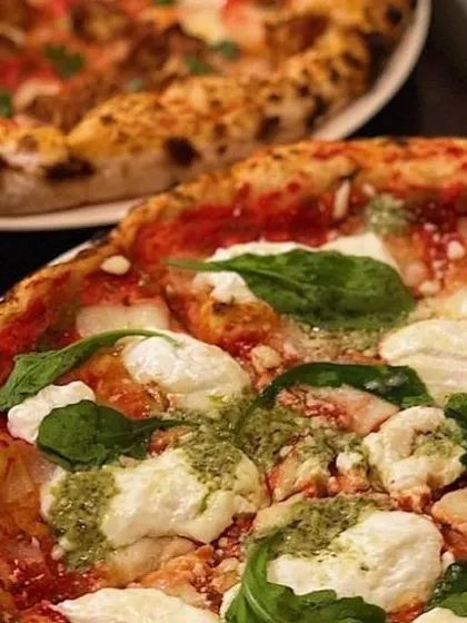 A close-up of my Pesto Burrata pizza, a fan favorite. The creamy dollops of burrata and swirls of green pesto make it as beautiful as it is delicious.