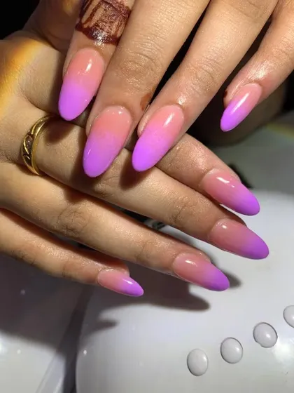 Mastering the ombre technique is essential for any nail tech. We teach you how to create a seamless color blend, like this pink and purple gradient on long, almond-shaped nails.