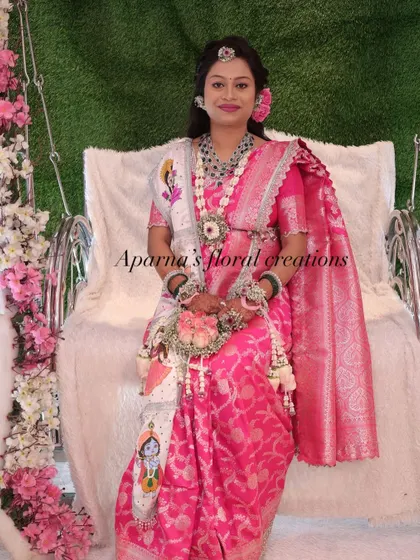 This mom-to-be is wearing a custom jewellery set that includes a unique floral sash with a painted Krishna motif for her Dohale Jevan.