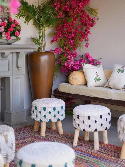 A close-up of the vibrant and cozy seating corner, with custom-printed cushions and macrame stools adding a touch of bohemian flair.