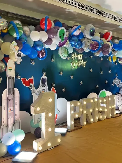 A side view of the space-themed stage, highlighting the large marquee '1' and a rocket ship prop ready for takeoff.