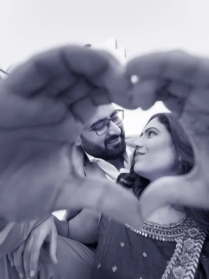 A classic heart-hands pose, framed to feel personal and intimate. This black and white version adds a timeless, romantic quality to the pre-wedding moment.