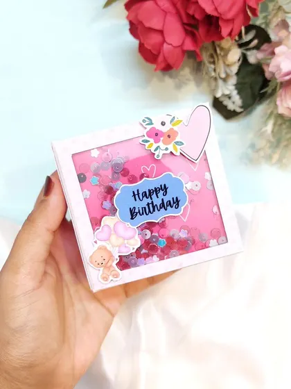 A mini scrapbook with a pink shaker cover, customized with a "Happy Birthday" message.