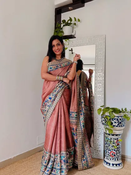 A beautiful dusty pink saree with a digital printed Paithani-style border. This gives the look of a traditional saree but in a lightweight, easy-to-manage fabric.