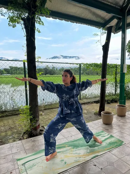 Holding Virabhadrasana II, or Warrior II pose, with strength and focus. The view of the mountains in the background is incredibly inspiring.