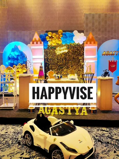 A royal prince theme for Agastya's first birthday. The setup features a castle backdrop, a golden shimmer wall, and even a miniature luxury car for the little prince to make a grand entrance.