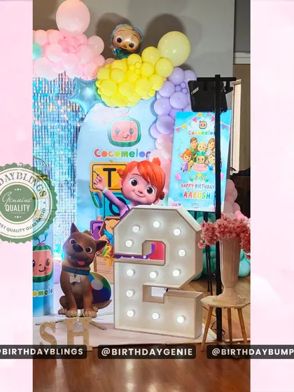 This view highlights the light-up number '2' and the placement of the character cutouts in the Cocomelon party setup.