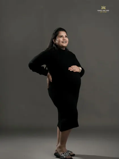 A simple yet powerful full-length portrait in our studio. The solid grey background and simple black dress beautifully accentuate the silhouette of the mom-to-be, capturing her anticipation and joy.