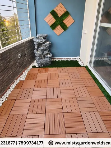 A wider view of the Kudlu Gate balcony, showing the water fountain, wall decor, and WPC flooring that create a complete and serene outdoor room.