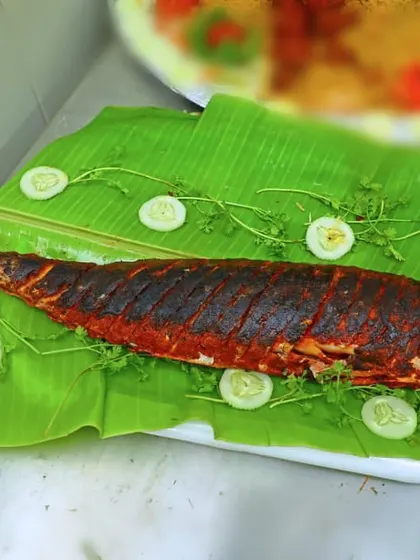 A whole fried fish, beautifully presented on a banana leaf. This is a popular choice for seafood lovers and adds a special touch to any menu.