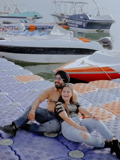 A happy, relaxed moment on a dock in Rishikesh. The background of boats and water adds a casual, vacation-like feel to this pre-wedding shoot.