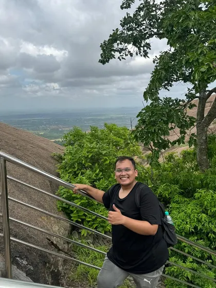 A happy trekker on the way up Uttari Betta. The trail has railings in steep sections, making it accessible for most fitness levels.