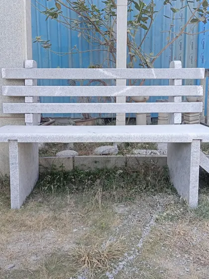 A front view of my popular slatted-back stone bench, suitable for parks, gardens, and public spaces.