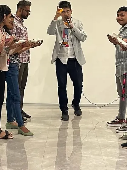 Leading a team building exercise where concentration is key. I am explaining the rules before the fun begins, ensuring everyone is on the same page for this ball-balancing challenge.