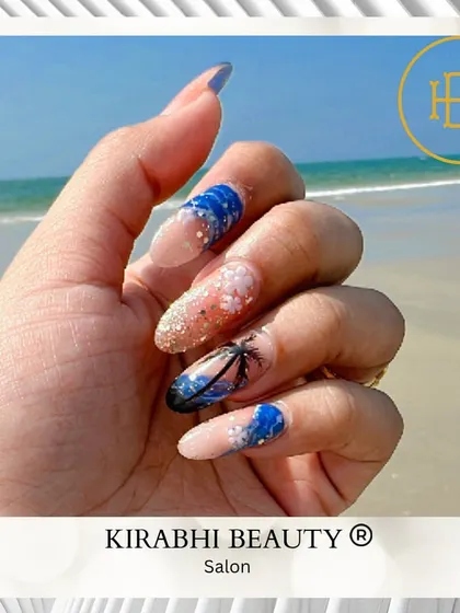 Your nails can be a whole vacation vibe. This beach-themed nail art includes glittery sand, blue ocean waves, and a hand-painted palm tree silhouette.