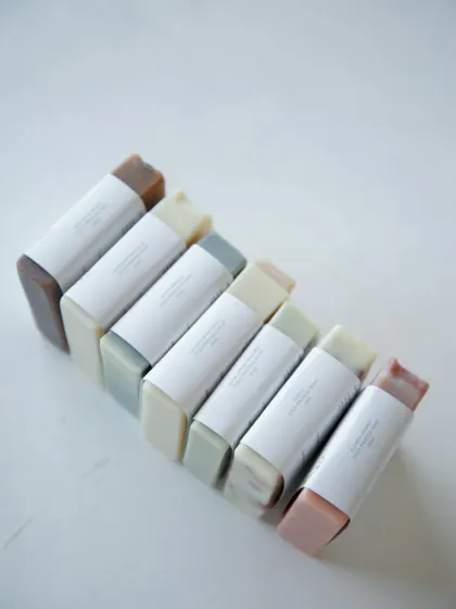 A clean, minimal shot of the assorted soaps with their simple white labels before the custom floral wraps were added.