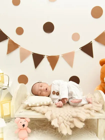 Another angle of the teddy bear theme, showing the baby sleeping peacefully under a banner of brown and beige flags.