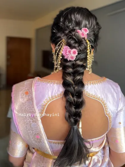 A lovely textured braid adorned with pink flowers and traditional gold earring chains (maatal) for a unique fusion look.
