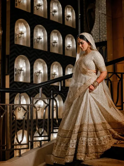 A graceful shot of the bride descending the stairs, showcasing the flow and elegance of her Walima outfit.