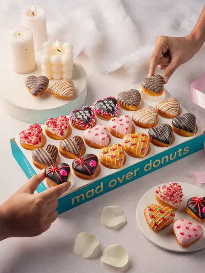 An interactive shot for Mad Over Donuts, with hands picking donuts from the box. This adds a human element and makes the product feel more desirable.