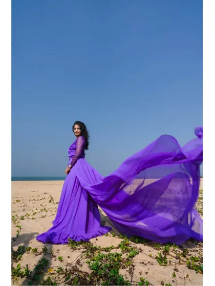 A solo shot of the lavender tail gown, showcasing its beautiful color and long, flowing train that looks stunning in an open, natural landscape.