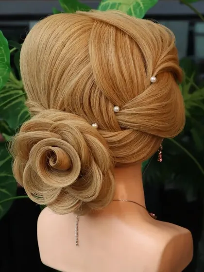 A side profile of the rose bun with leaf element detailing. The hair quality allows for creating these fine, separated lines that define advanced hairstyles.