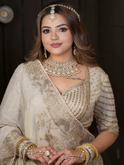 A stunning ivory and gold lehenga, perfect for the bride who wants a regal and timeless look. The heavy choker and matha patti complete this rental ensemble.