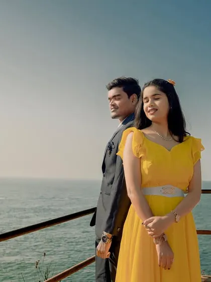 A bright and cheerful pre-wedding shoot by the sea. The bride's sunny yellow dress and the groom's classic suit create a happy and stylish vibe.