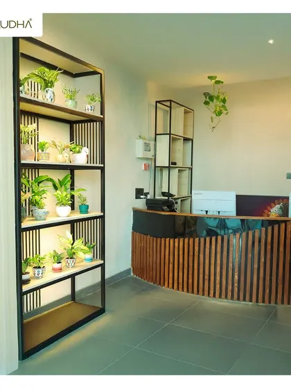 The reception desk of a commercial space, where first impressions matter. I designed this custom desk with a curved wooden slat front and added a tall, backlit shelving unit filled with plants to create a striking, modern look.