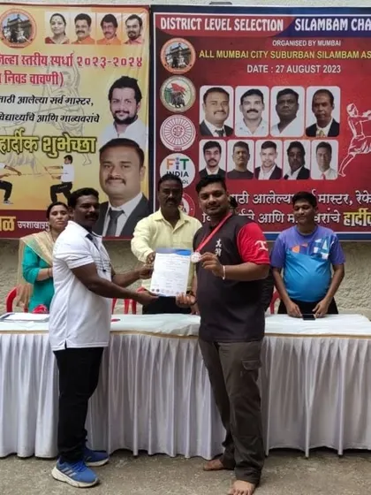 A student receiving his medal and certificate at the Silambam district championship. It's a great experience for them.