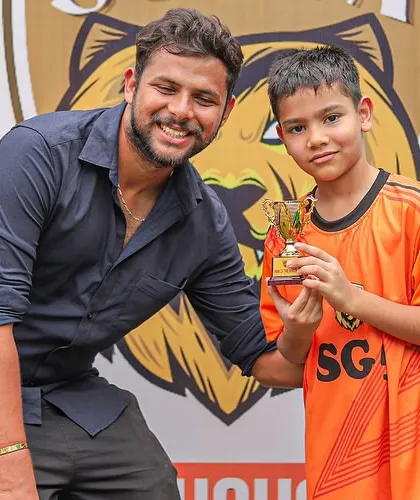 A young player receiving his Player of the Match trophy from our founder during the Inter SG5 Cup.
