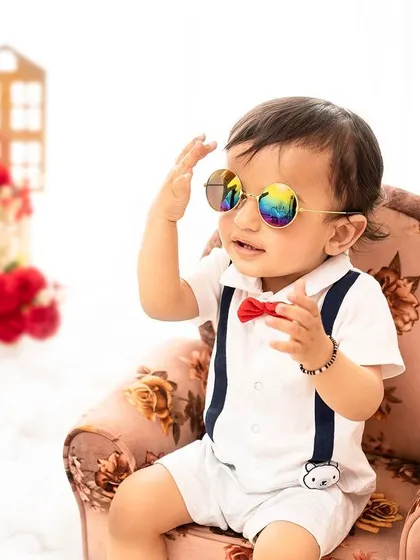 A cool little dude with his sunglasses. This fun and stylish portrait captures the playful side of a one-year-old's personality.