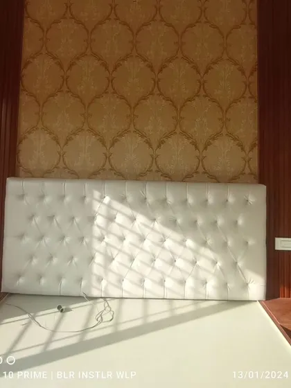 A damask wallpaper installed as a panel behind a tufted headboard.
