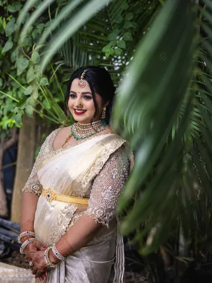 This client looks absolutely stunning in her off-white saree for her son's naming ceremony. The custom-designed blouse with intricate pearl embroidery adds a touch of glamour to her look.