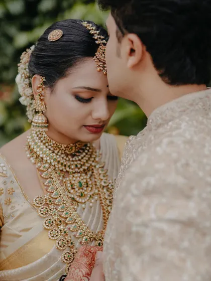 A romantic shot of the couple, her makeup soft and glowing, perfectly complementing the tender moment.