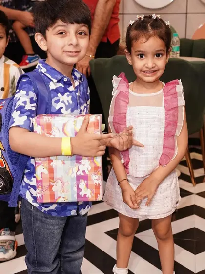 Two young guests, one with a cool car-themed backpack, pose for a photo.