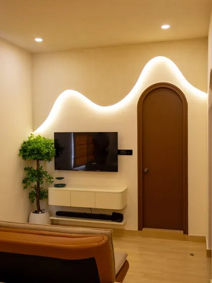 The wavy wall motif continues in this bedroom's TV unit, creating a sense of cohesive, organic design throughout the home.
