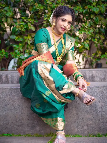 A fun and traditional pose, showing the comfort and style of a well-draped Nauvari.