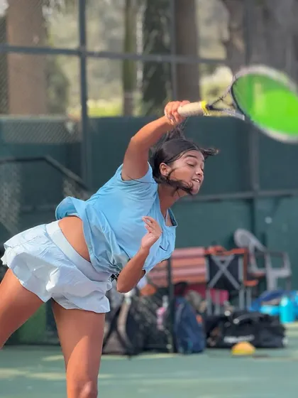 Capturing the power and grace of a well-practiced serve. One of our female junior players demonstrates excellent form and explosive movement during a practice session.