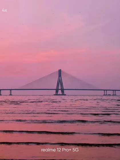 A 4x zoom mobile photograph of the Sea Link, bringing the structure closer while still retaining the beautiful pink hues of the water and sky.