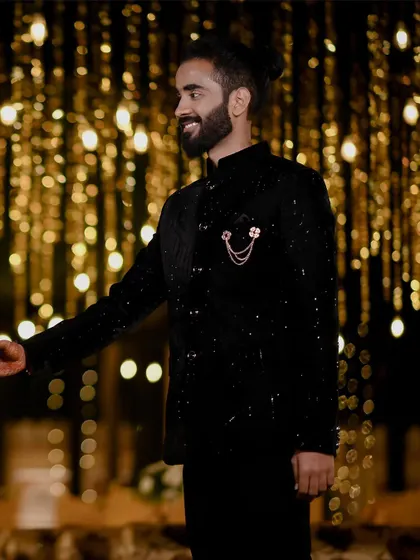 A stylish portrait of the groom, Aman, against a backdrop of fairy lights.