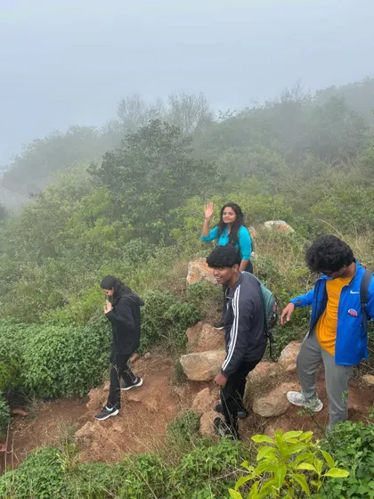Students navigating a misty, green trail during their trek. We guide groups through diverse terrains, teaching resilience and adaptability along the way.