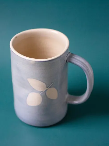 A single Snowflake mug, highlighting its tall, elegant shape and the subtle variations in the hand-applied blue glaze. This is a perfect example of a unique, artisan-made ceramic beer mug.