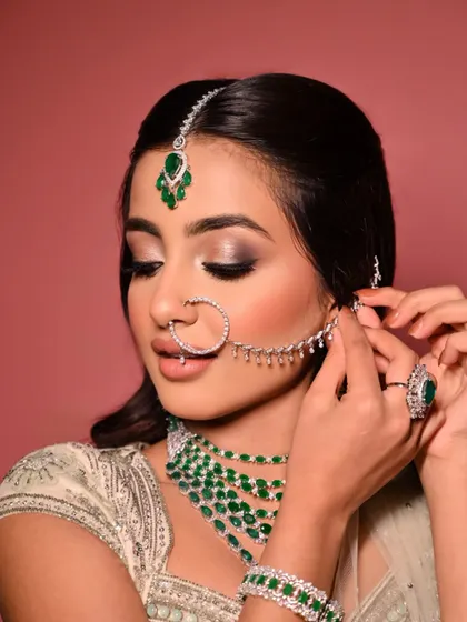 A beautiful shot showcasing the soft, blended eyeshadow and the delicate details of the jewellery. The hair is styled in a classic half-updo to keep the focus on the face and accessories.